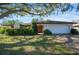 Charming single-story home featuring a two-car garage and a well-manicured front yard with mature trees and lush landscaping at 3640 Aster Dr, Sarasota, FL 34233