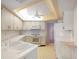 Bright kitchen with white cabinets, appliances, and a ceiling fan at 3640 Aster Dr, Sarasota, FL 34233
