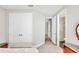 Bright bedroom hallway with grey walls, double doors, and entry to bathroom at 3663 Quiet Dr, Sarasota, FL 34240