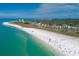 Stunning aerial view of a coastline with turquoise waters, a sandy beach, and vibrant buildings, showcasing a lively coastal community at 3979 Helene St, Sarasota, FL 34233