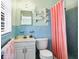 Charming bathroom with blue tile, a pink shower curtain, and vintage-style fixtures at 4008 Cape Vista Dr, Bradenton, FL 34209