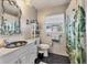 Bright bathroom featuring an ornate mirror, white tile, and a tropical-themed shower curtain at 4008 Cape Vista Dr, Bradenton, FL 34209