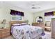 Cozy bedroom featuring a floral-patterned quilt, coordinated lamps, and natural light from a shuttered window at 4008 Cape Vista Dr, Bradenton, FL 34209