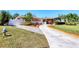 Exterior view of a charming home with a well-kept lawn, mature trees, and a long driveway for multiple cars at 4008 Cape Vista Dr, Bradenton, FL 34209