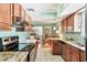 Functional kitchen area with granite countertops, wooden cabinets, and access to dining area at 4008 Cape Vista Dr, Bradenton, FL 34209