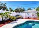 Backyard featuring a kidney-shaped pool, a lounging area, lush landscaping, and privacy fencing at 4008 Cape Vista Dr, Bradenton, FL 34209