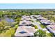 Overhead view of homes with lush green lawns, mature trees, and a tranquil lake, offering a serene community at 4451 Atwood Cay Cir # 7, Sarasota, FL 34233
