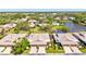 Aerial view of homes with well-maintained lawns, mature trees, pool and serene lake, offering a community feel at 4451 Atwood Cay Cir # 7, Sarasota, FL 34233
