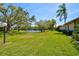 Picturesque backyard with a tranquil pond view, mature trees, and manicured lawn, perfect for relaxation at 4451 Atwood Cay Cir # 7, Sarasota, FL 34233
