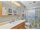 Bathroom featuring a large mirror, under-cabinet storage, and decorative tropical shower curtain at 4451 Atwood Cay Cir # 7, Sarasota, FL 34233