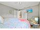 Cozy bedroom features a mounted TV, a chest of drawers, and a tropical accent chair at 4451 Atwood Cay Cir # 7, Sarasota, FL 34233