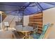 Shaded patio with a dining table, chairs, and a large blue umbrella at 4451 Atwood Cay Cir # 7, Sarasota, FL 34233