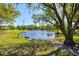 Community pond with picturesque landscaping and a large shade tree at 4451 Atwood Cay Cir # 7, Sarasota, FL 34233