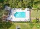 Aerial view of a large community pool surrounded by a patio and trees in a relaxing and private setting at 4451 Atwood Cay Cir # 7, Sarasota, FL 34233