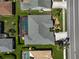 Aerial shot displaying a home with a screened pool area, surrounded by lush greenery and neighboring properties at 457 Lake Of The Woods Dr, Venice, FL 34293