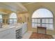 Bathroom with dual sinks, ample counter space, and arched windows for natural light at 457 Lake Of The Woods Dr, Venice, FL 34293
