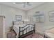 Comfortable bedroom featuring a black metal bed frame, colorful rug, and overhead fan at 457 Lake Of The Woods Dr, Venice, FL 34293