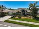 Well-maintained home with a landscaped front yard, complemented by palm trees and a two-car garage at 457 Lake Of The Woods Dr, Venice, FL 34293