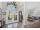 Grand foyer with high ceilings, double doors, decorative tile, and an elegant grandfather clock at 457 Lake Of The Woods Dr, Venice, FL 34293