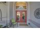 Inviting entryway features double doors, decorative glass, and an arched window, complemented by outdoor seating at 457 Lake Of The Woods Dr, Venice, FL 34293