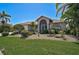 Well-maintained single-story home featuring lush landscaping, a front lawn, and a welcoming entryway with an arched window at 457 Lake Of The Woods Dr, Venice, FL 34293