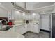 Bright kitchen with modern white cabinets and stainless steel refrigerator and appliances at 457 Lake Of The Woods Dr, Venice, FL 34293