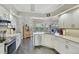 Bright kitchen with white cabinetry, stainless steel appliances, and view of backyard and pool at 457 Lake Of The Woods Dr, Venice, FL 34293