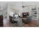 Spacious living room features vaulted ceilings, wood floors, leather reclining sofas, and a ceiling fan at 457 Lake Of The Woods Dr, Venice, FL 34293