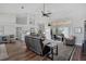 Bright living room with hardwood floors, modern decor, a ceiling fan, and sliding glass doors to the patio at 457 Lake Of The Woods Dr, Venice, FL 34293