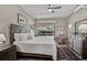 Spacious primary bedroom boasts a king bed, wood floors, and a view to the pool at 457 Lake Of The Woods Dr, Venice, FL 34293