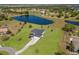 Expansive aerial view of single-story home featuring a private pond, lush green lawn, and long concrete driveway at 4606 Lake Fox Pl, Parrish, FL 34219