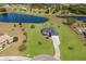 Aerial view of a home with a manicured lawn, long driveway, and scenic pond, creating a serene living environment at 4606 Lake Fox Pl, Parrish, FL 34219