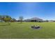 Large backyard with green lawn, lake view, and inviting fire pit, perfect for outdoor living at 4606 Lake Fox Pl, Parrish, FL 34219