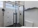 Shower with geometric tiles, glass doors, and sleek black fixtures for a modern design at 4606 Lake Fox Pl, Parrish, FL 34219