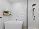 Bright bathroom featuring a standalone tub, glass-enclosed shower, and marble-style tiled walls at 4606 Lake Fox Pl, Parrish, FL 34219