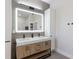 Modern bathroom featuring double vanity, lighted mirror, and sleek fixtures in neutral color palette at 4606 Lake Fox Pl, Parrish, FL 34219