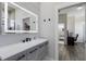 Bathroom with lighted mirror, a vanity, and view into attached room at 4606 Lake Fox Pl, Parrish, FL 34219
