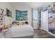 Bright bedroom with a white bed, colorful wall decor, and wood-look floors at 4606 Lake Fox Pl, Parrish, FL 34219