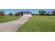 Long concrete driveway leading to a well-kept home with a spacious three-car garage and landscaped lawn at 4606 Lake Fox Pl, Parrish, FL 34219