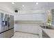 Bright kitchen featuring white cabinets, stainless steel appliances, and a tiled floor at 4606 Lake Fox Pl, Parrish, FL 34219
