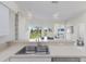 Kitchen with view to the backyard and lake, stainless steel appliances, with breakfast bar and stylish pendant lights at 4606 Lake Fox Pl, Parrish, FL 34219