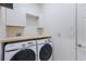 Bright laundry room equipped with a new Samsung washer and dryer and overhead cabinets at 4606 Lake Fox Pl, Parrish, FL 34219