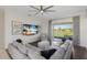 Spacious living room with a large window, ceiling fan, and a comfortable sectional sofa at 4606 Lake Fox Pl, Parrish, FL 34219