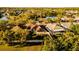 Aerial view of a single-Gathering home with lush greenery surrounding it and a pond near by at 4706 Cayo Costa Pl, Bradenton, FL 34203
