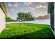 Large, grassy backyard with a white fence, trees and ample space for outdoor activities at 4706 Cayo Costa Pl, Bradenton, FL 34203