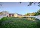 Spacious, flat backyard featuring lush green grass, a white picket fence, and ample space for outdoor activities at 4706 Cayo Costa Pl, Bradenton, FL 34203