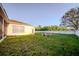 Spacious backyard with lush green grass, surrounded by a white fence, a trampoline and some chairs at 4706 Cayo Costa Pl, Bradenton, FL 34203