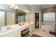 Traditional bathroom with a double sink vanity, large mirrors, soaking tub, and neutral color palette at 4706 Cayo Costa Pl, Bradenton, FL 34203