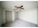A carpeted bedroom with a ceiling fan and two closets at 4706 Cayo Costa Pl, Bradenton, FL 34203