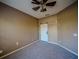 Neutral bedroom featuring carpeting, a ceiling fan, and a sliding barn door at 4706 Cayo Costa Pl, Bradenton, FL 34203